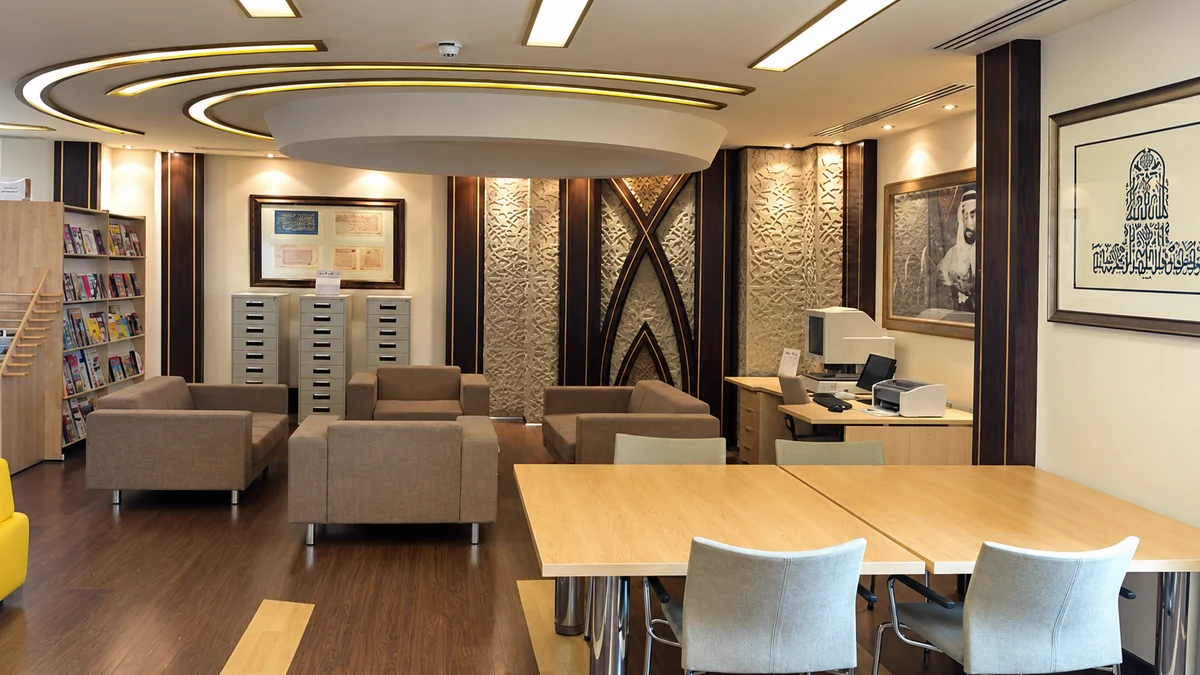 Reading lounge with a curved gypsum ceiling and carved timber wall panels