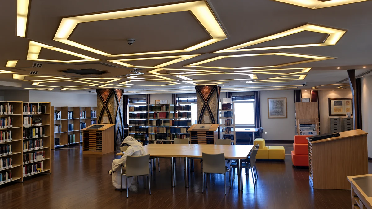 Library reading room beneath a geometric illuminated ceiling
