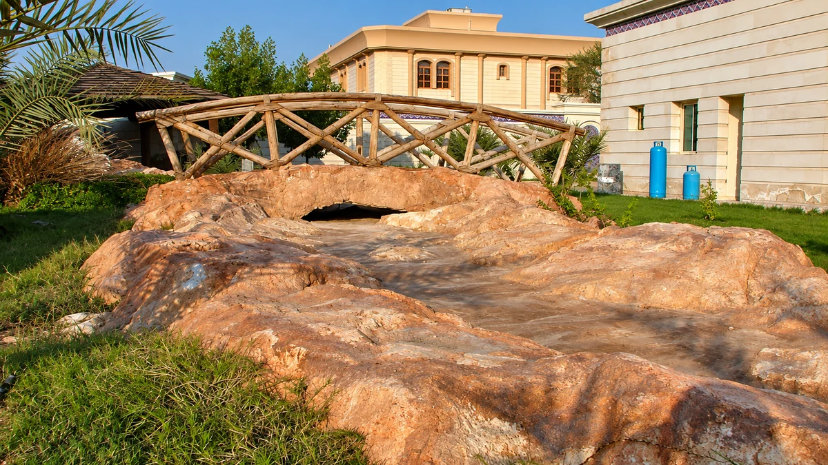 Sculpted rock streambed crossed by a rustic timber log bridge