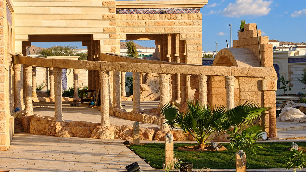 Stone colonnade and pergola framing a newly planted palm garden