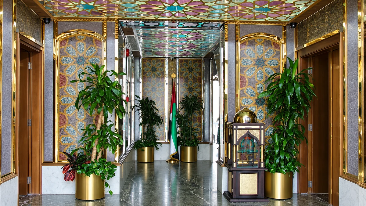 VIP entrance hall lined with mosaic panels beneath a stained glass ceiling