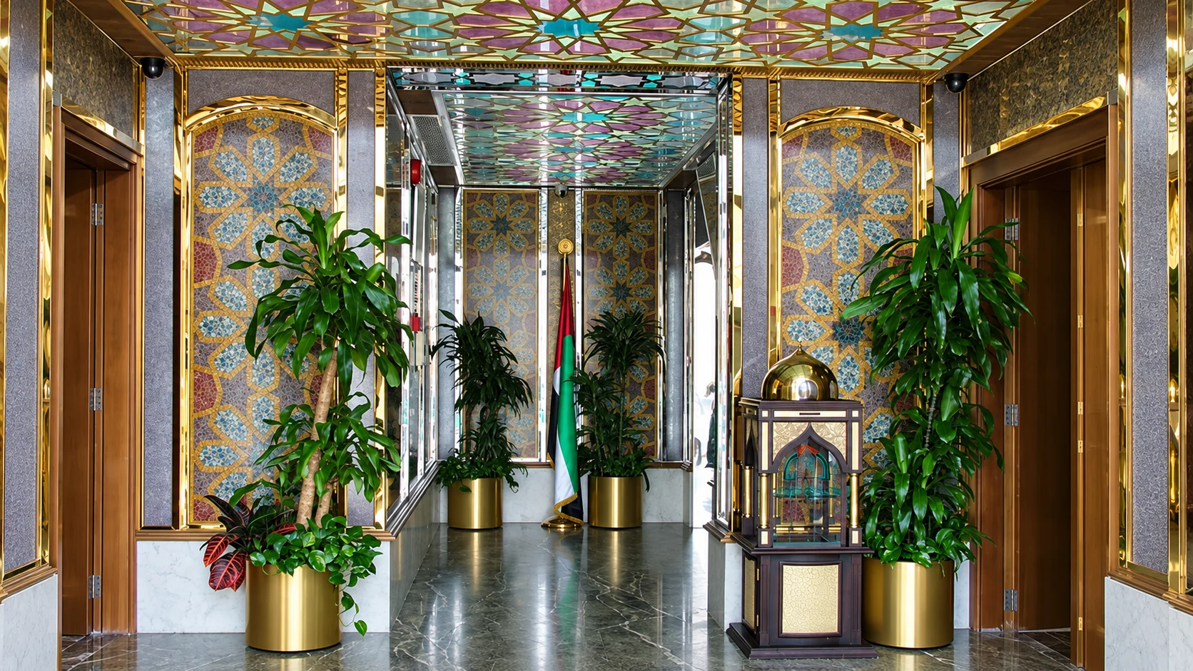 VIP entrance hall lined with mosaic panels beneath a stained glass ceiling